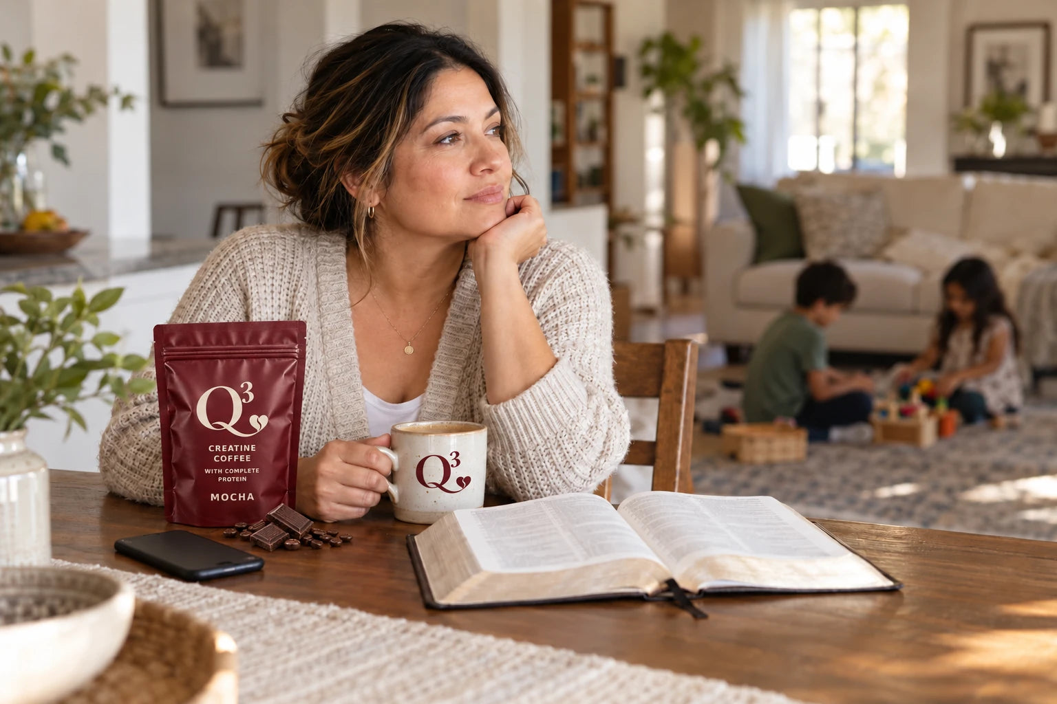 A mother taking a quiet coffee and reading break while her children play nearby